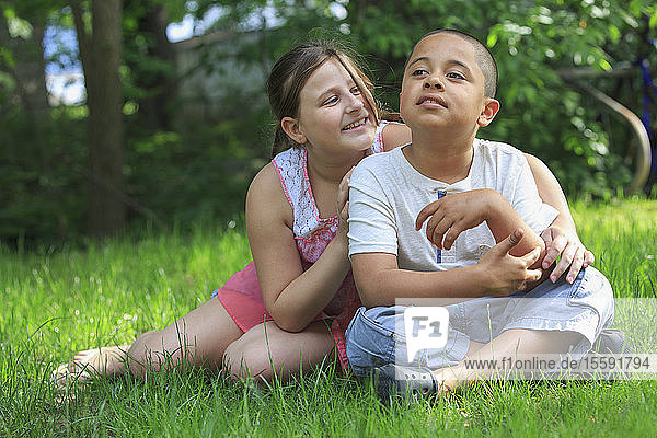 Hispanischer Junge mit Autismus spielt draußen mit seiner Schwester
