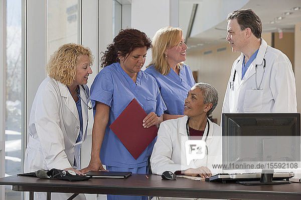 Doctors and nurses consulting on a computer in hospital