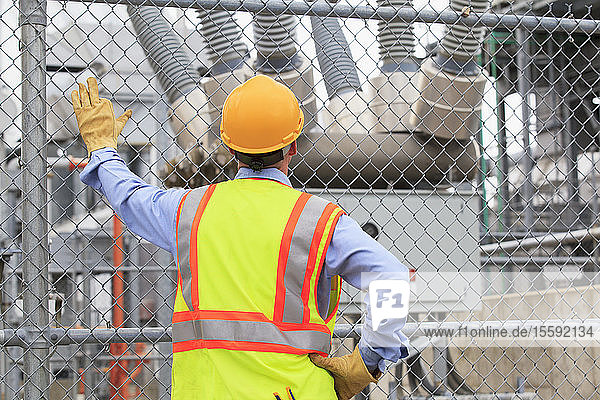 Electrical engineer examining transformers inside of an electric power plant