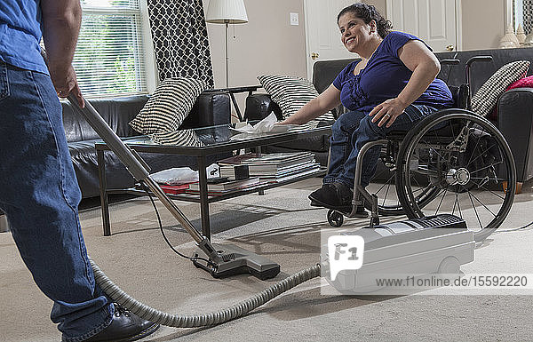 Frau mit Spina Bifida und ihr Mann putzen ihr Haus