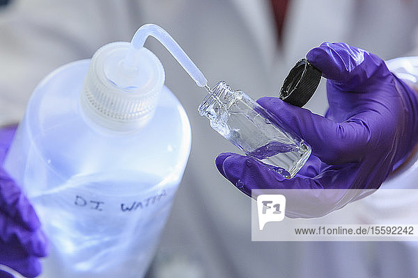 Chemielaborant fügt der Probe destilliertes Wasser zu