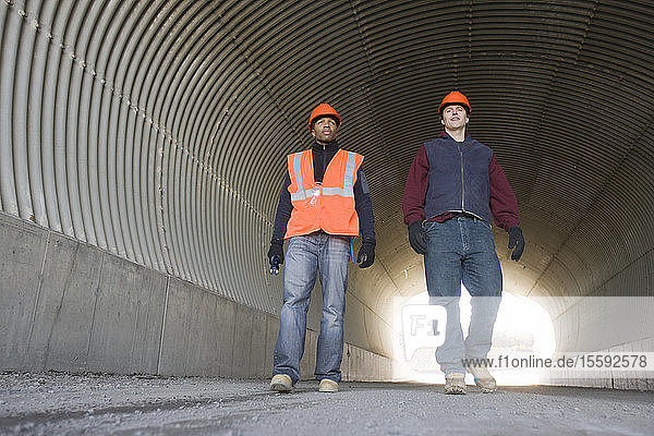 Two engineers walking in a tunnel