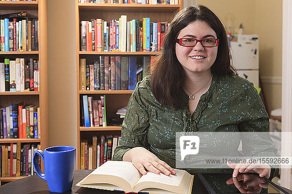 Woman with Asperger syndrome relaxing with a mug of tea and a book