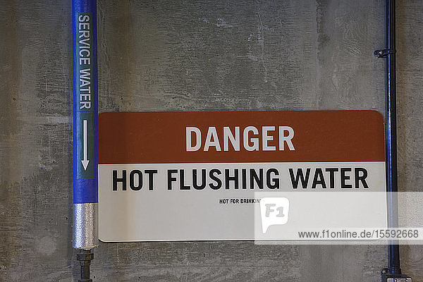 Heißspülwasserleitung mit Warnschild in einer Kläranlage