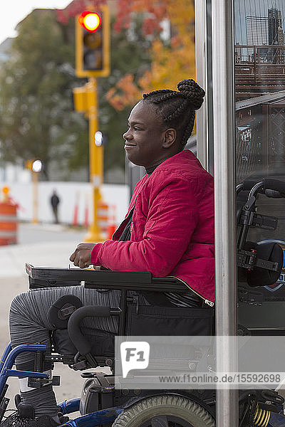 Teenager mit zerebraler Lähmung an der Bushaltestelle