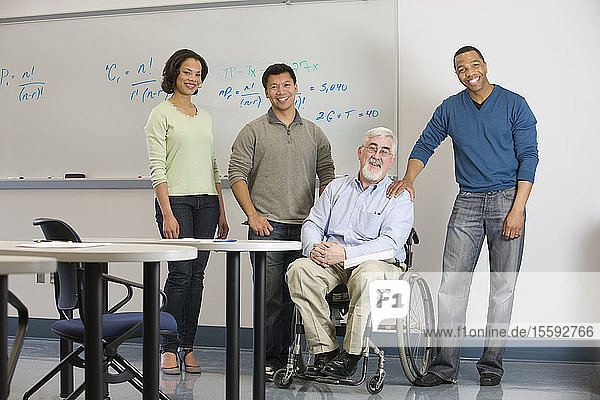 Universitätsprofessor mit Muskeldystrophie mit seinen Studenten in einem Klassenzimmer