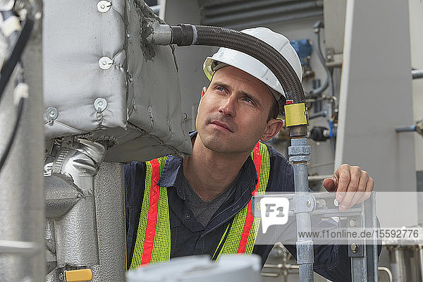 Industrial engineer examining high temperature sensor connections at a power plant