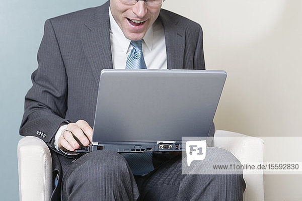 Blick auf einen Geschäftsmann  der an einem Laptop arbeitet.