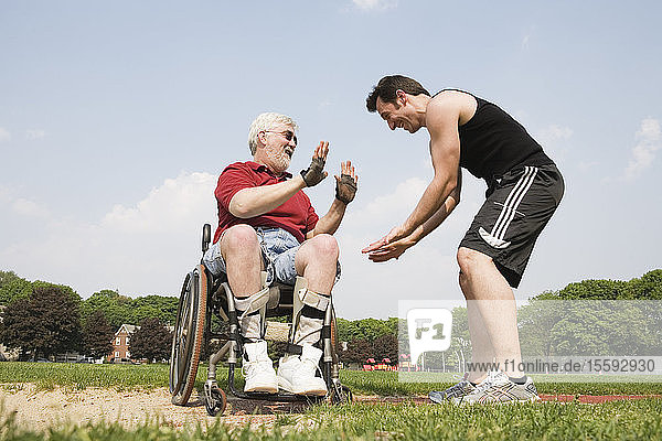 Man with Muscular Dystrophy shaking hands with runner on a race track