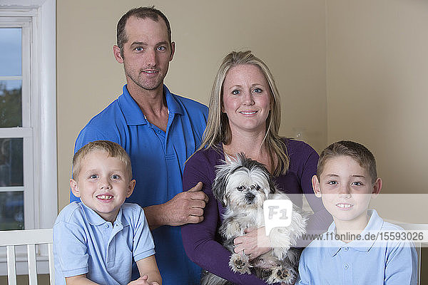 Porträt einer glücklichen Familie mit Hörbehinderung und einem Welpen