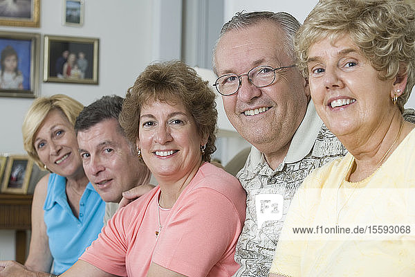 Eine Gruppe von Senioren lächelt gemeinsam in einem Heim