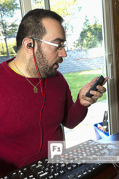 Mann mit Sehbehinderung hört sein Telefon ab