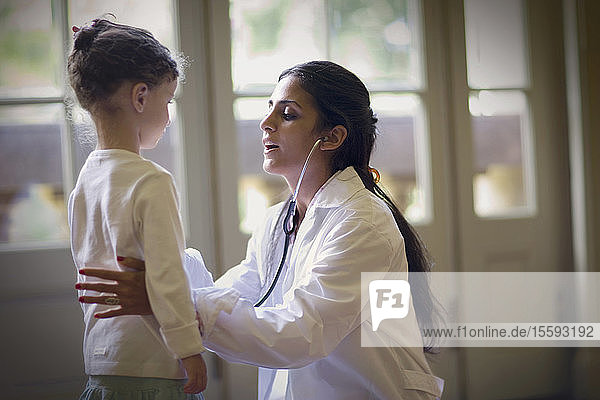 Blick auf eine Ärztin  die ein kleines Mädchen untersucht