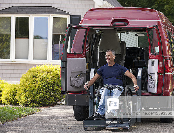 Ein Mann mit einer Rückenmarksverletzung im Rollstuhl steigt in seinen Lieferwagen ein