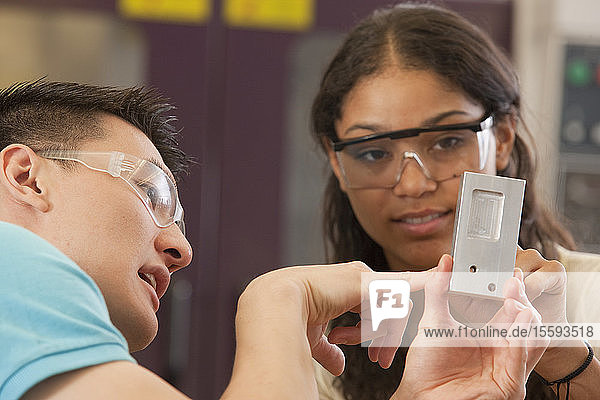 Ingenieurstudenten bei der Prüfung eines bearbeiteten Teils in einem Labor