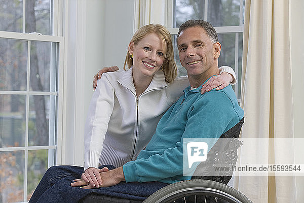 Man sitting in a wheelchair with a woman beside him