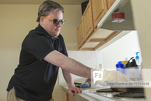Mann mit angeborener Blindheit benutzt seinen Küchenherd