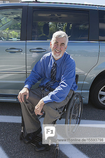 Mann mit Muskeldystrophie und Diabetes im Rollstuhl neben einem behindertengerechten Lieferwagen