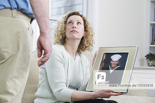 Frau zeigt Bild ihres Sohnes  der beim Militär arbeitet