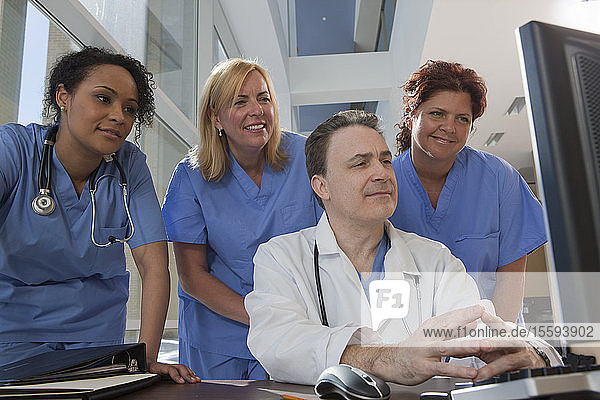 Doctor and nurses consulting on a computer in hospital