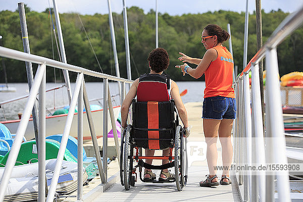 Woman with a Spinal Cord Injury talking to an instructor about using a kayak