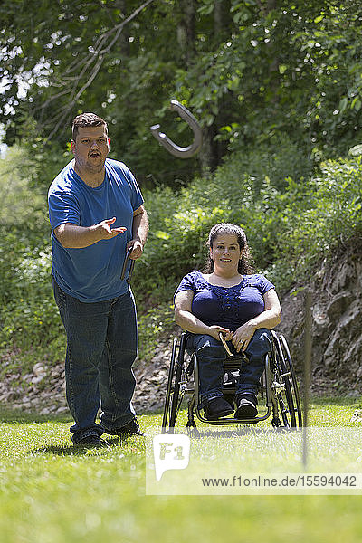 Woman with Spina Bifida in a wheelchair playing horseshoes with her husband