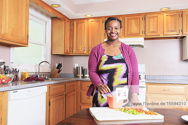 Frau mit Lernbehinderung beim Kochen in der Küche