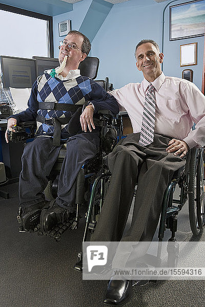 Zwei Geschäftsleute in einem Büro  einer mit Muskeldystrophie und Beatmungsgerät  der andere mit Rückenmarksverletzung