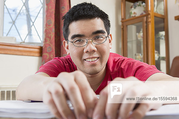 Porträt eines glücklichen asiatischen Mannes mit Autismus bei der Arbeit in seinem Haus