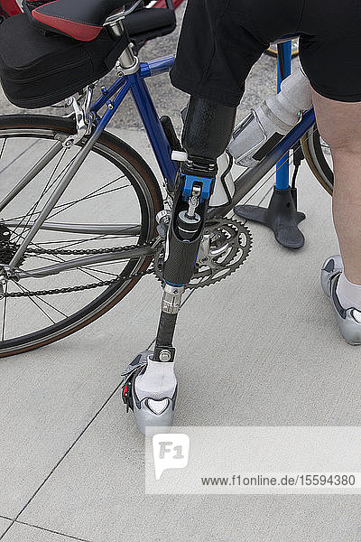 Frau mit Beinprothese bereitet sich auf ein Radrennen vor