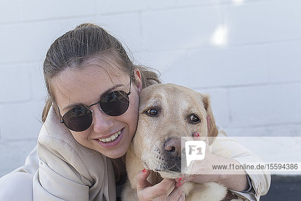 Junge blinde Frau  die ihren Diensthund umarmt