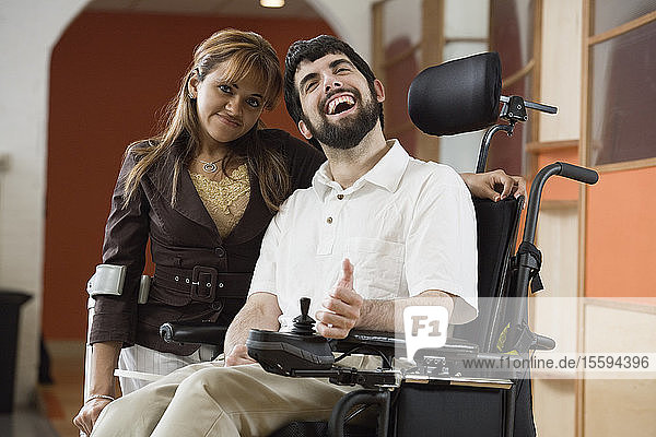 Porträt eines Mannes mit zerebraler Lähmung und einer lächelnden Frau.