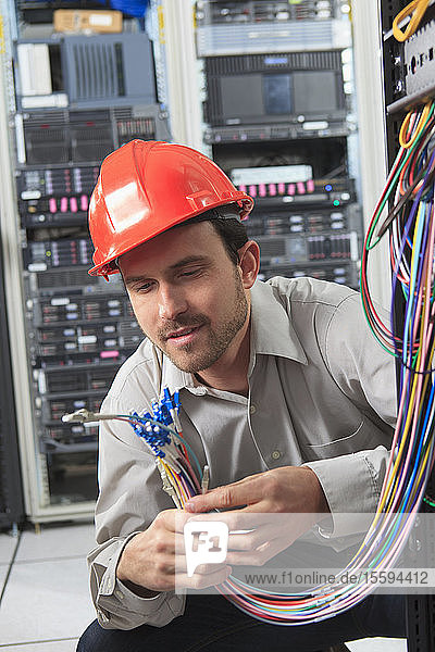 Network engineer preparing fiber cables in data center