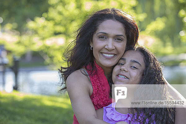 Portrait of happy Hispanic woman and her teen daughter with braces