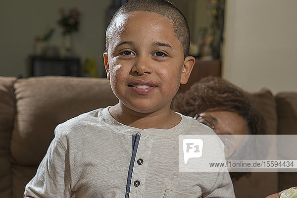 Hispanischer Junge mit Autismus sitzt mit seiner Großmutter zu Hause