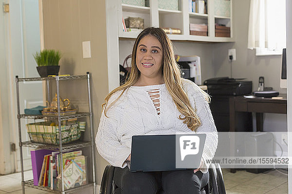 Frau mit Rückenmarksverletzung arbeitet an ihrem Computer