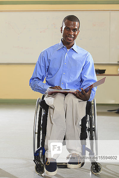 Engineering student in an electronics classroom in a wheelchair from Spinal Meningitis