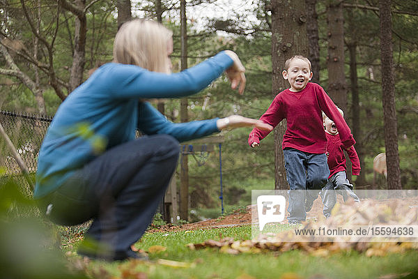 Frau  die das Wort Jump in amerikanischer Gebärdensprache gebärdet  während sie mit ihrem Sohn in einem Park kommuniziert