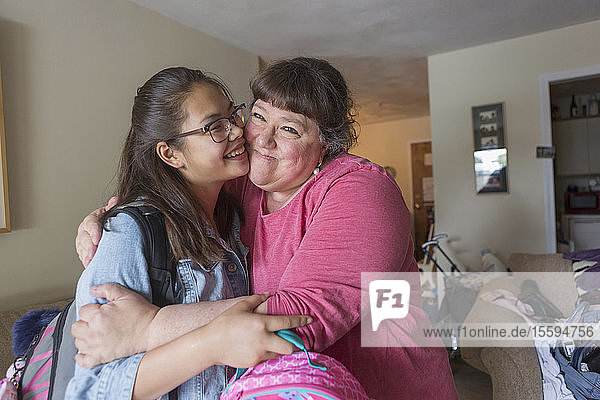 Mutter umarmt ihre Tochter  die eine Lernbehinderung hat
