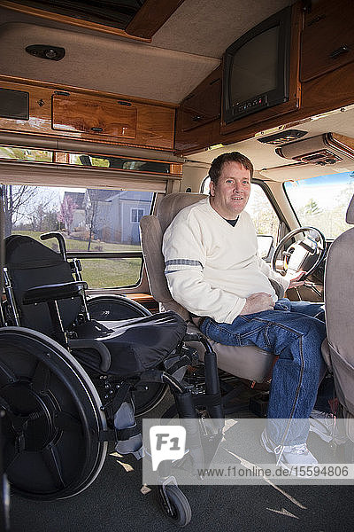 Man with spinal cord injury getting into the driver's seat from his wheelchair in accessible van