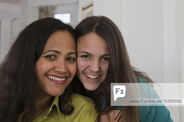 Hispanic woman smiling with her teenage daughter