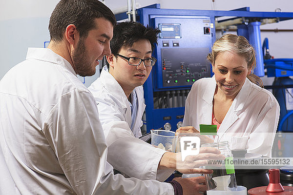 Engineering students examining liquid containers in water ultra purification system room in a laboratory