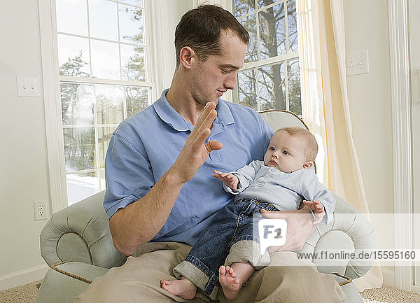 Mann  der das Wort B in amerikanischer Zeichensprache gebärdet  während er mit seinem Sohn kommuniziert