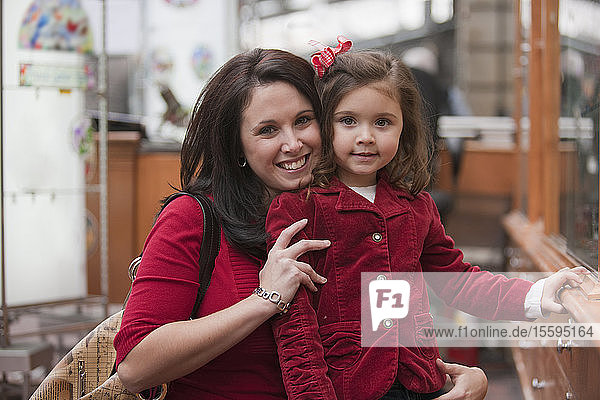 Porträt einer Frau  die mit ihrer Tochter beim Einkaufen auf dem Quincy Market lächelt