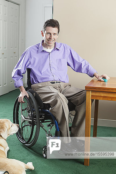Querschnittsgelähmter Mann im Rollstuhl mit Rückenmarksverletzung öffnet Pillenschachtel