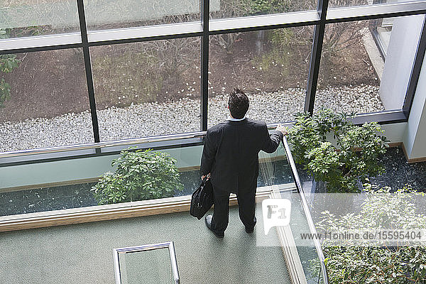 Geschäftsmann mit Aktentasche im Atrium eines Bürogebäudes