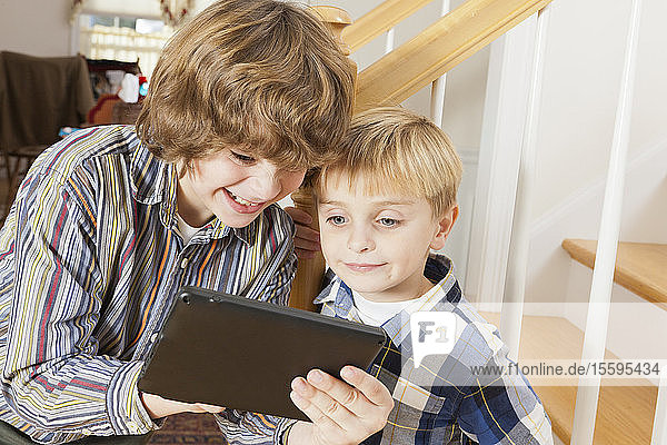 Nahaufnahme von zwei Brüdern  die auf einem digitalen Tablet spielen