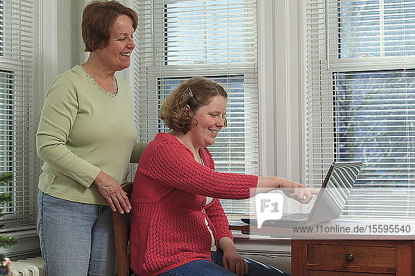 Young woman with Autism and her mother using their laptop