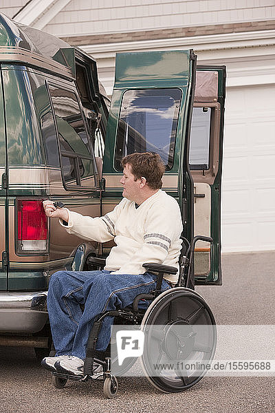 Ein Mann mit einer Rückenmarksverletzung benutzt eine magnetische Fernbedienung  um sein zugängliches Fahrzeug zu schließen
