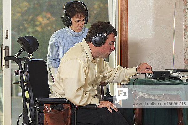 Ehepaar mit Cerebralparese benutzt Kopfhörer mit ihrem Radio